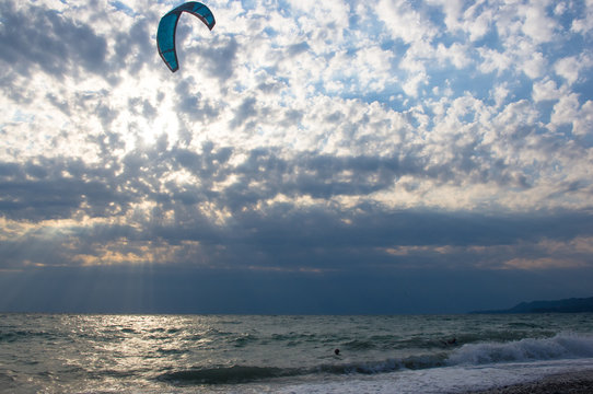 kitesurfer rides a kite-surf on waves of the sea