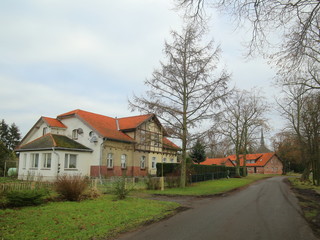 Fototapeta na wymiar Bisdorfer Strasse in Griebenow, Germany. The historical buildings are part of the former palace grounds of the town