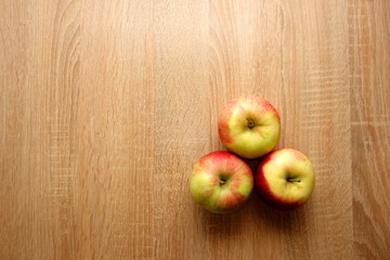 Three fresh apples on rustic wooden background with copy space for your design