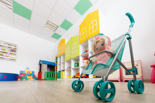  oll in a toy carriage close-up and Shelves with toys in child room