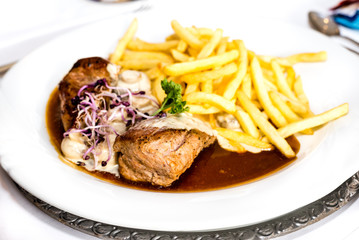 Schweinemedaillons mit Pilzen und Pommes frites und Rahmsoße