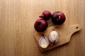 Organic red onion on wooden table, copy space for your design