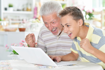 portrait of  boy and  grandfather with a laptop 