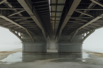 Under Chernavsky Bridge through Voronezh river at foggy winter day