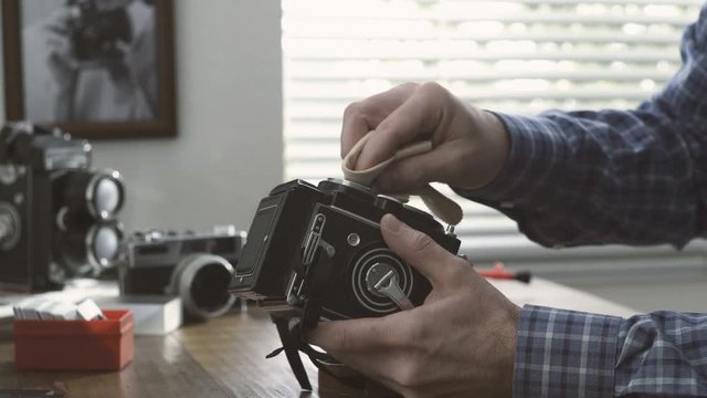 Professional photographer cleaning a twin lens camera
