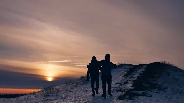 people winter silhouette does selfie photograph joy snow sunlight. group of tourists walking on top of a sunset silhouette mountain. slow video tourists people lifestyle group go travel nature