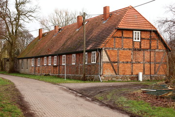 Fototapeta na wymiar Row of rural workers houses, listed as monument in Schmoldow, Mecklenburg-Western Pomerania, Germany