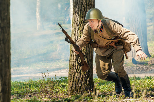 Soviet soldier with a Mosin-Nagant rifle and helmet in action in uniform of the World war 2 period, historical reenactment