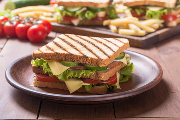 Club sandwich with tomatoes , cucumber , ham and cheese