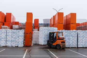 Brown decorative bricks stacked on a pallet on a blurred background of other building material
