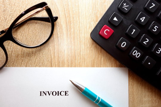 Business accounter work with invoice form, calculator, glasses and pen