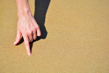 the girl is hand on the sand with place for text