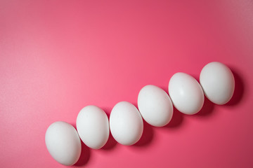 Minimal Easter concept. Top view. White eggs on pink background. Close up. Copy space. Flat lay.