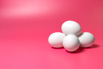 Easter minimal concept. Front view. White farm chicken eggs on pink background. Close up. Copy space.