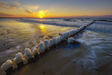 Fototapeta premium A beautiful sunset over the sandy beach on the Wolin Island in Poland in the winter