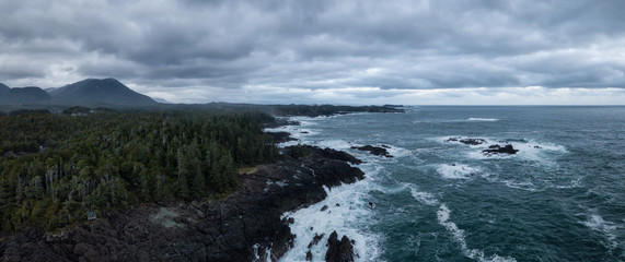 Obraz premium Aerial panoramic seascape view of a rocky Pacifc Coast during a gloomy winter sunset. Taken near Ucluelet, Vancouver Island, British Columbia, Canada.