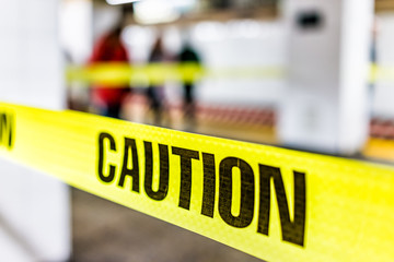 Caution tape sign in underground transit empty large platform in New York City NYC Subway Station in Grand Central, ladder, wet floor cone