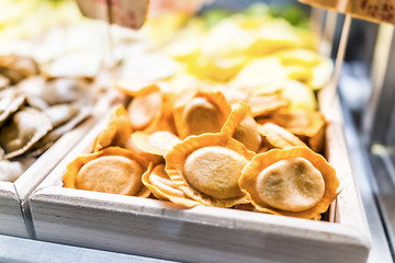 Macro closeup of yellow orange pumpkin ravioli pasta cheese filling fresh raw uncooked in italian gourmet market