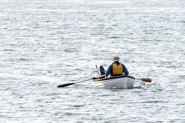 Fototapeta na wymiar Person rowing in San Francisco Bay. Rowing. Rowing just might be the most efficient exercise.