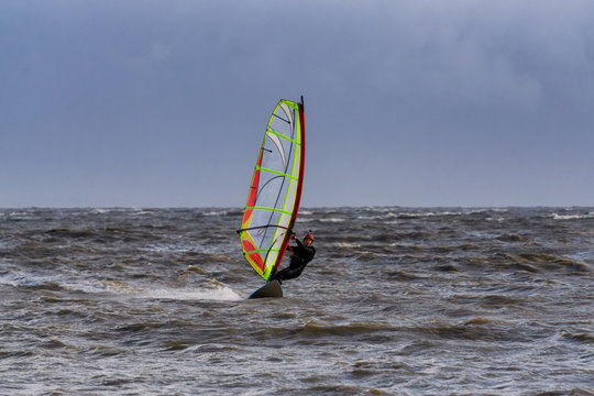 Adventurous man is windsurfing in stormy winter conditions. Taken in Centennial Beach, Delta, Greater Vancouver, British Columbia, Canada.