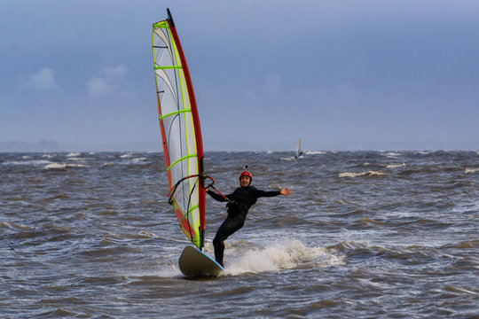 Adventurous man is windsurfing in stormy winter conditions. Taken in Centennial Beach, Delta, Greater Vancouver, British Columbia, Canada.