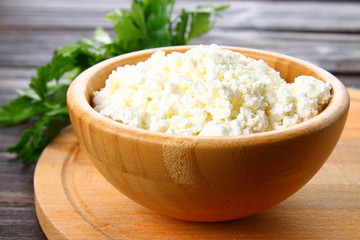 Home cottage cheese in a bowl on a wooden table.