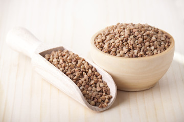 Buckwheat groats in a wooden bowl and  in a wooden spoon