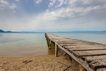 Fototapeta premium Old wooden pier and sea in cloudy day. Eastern side of Corfu island.