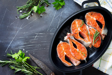 Fresh salmon pickled for a barbecue on a cast-iron frying pan. Copy space, top view flat lay background.