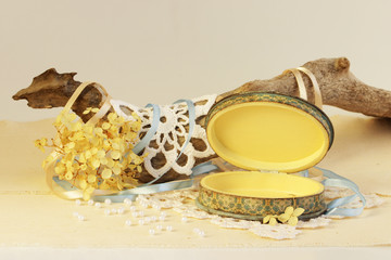 open oval wooden box of hand work, yellow and blue. Dry root of the tree, white knitted napkins, dry hydrangea