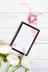 Empty dark frame decorated with pink hearts and white flowers