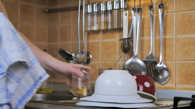 A man wiping dishes in the kitchen