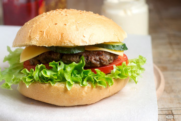 Homemade hamburger with fresh vegetables served with various sauces.