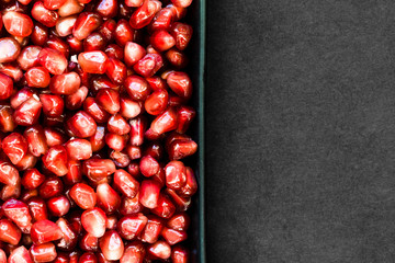Pomegranate Seeds in the Plate and Black Background with Free Space