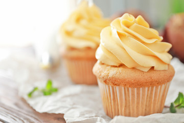 Tasty cupcake with cream on table