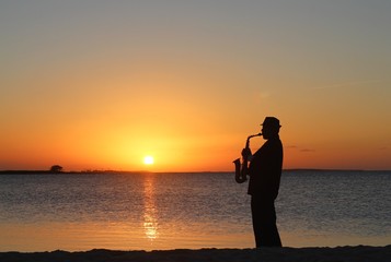 Cuban musician playing saxophone in the sunset