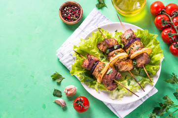 Grilled shish kebab or shashlik on green table.