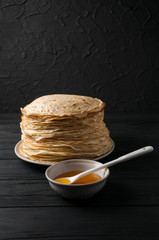 Homemade pancakes with honey and walnuts, vintage white plate, dipper, dark wooden table