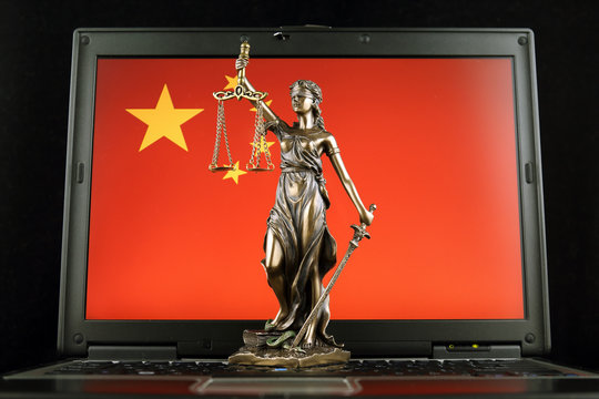 Symbol of law and justice with China Flag on laptop. Studio shot.