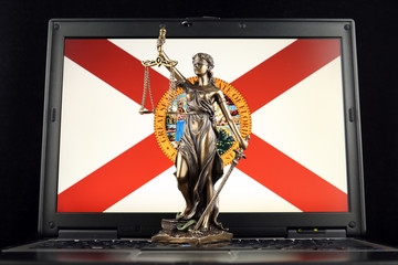 Symbol of law and justice with Florida State Flag on laptop. Studio shot.