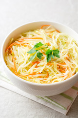 Fresh coleslaw salad in bowl on gray stone background.