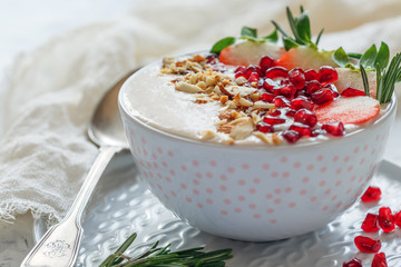 Healthy smoothie bowl of strawberries, pomegranate and almonds.