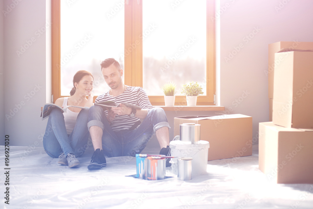 Wall mural couple moving in house sitting on the floor