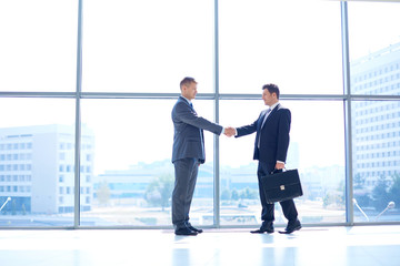 Obraz premium Full length image of two successful business men shaking hands with each other