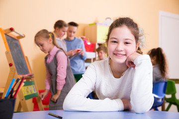 Smiling schoolgirl in classroom during break