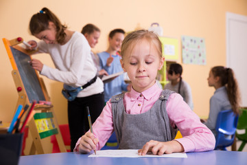Fototapeta premium Schoolgirl drawing at break in school