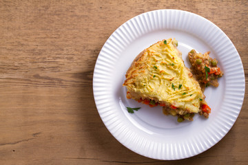 Traditional shepherd pie - popular dish in Ireland. Beef meat, mashed potato, cheese, carrot, onion and green peas casserole. View from above, top