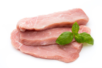 Fresh pork fillet with basil on a white background.