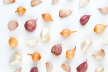 Onion and garlic isolated on white background, top view. Wallpaper abstract composition of vegetables.