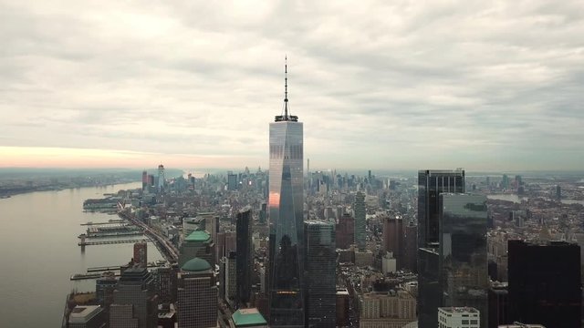 Freedom Tower aerial flying moving toward skyscraper in Manhattan New York City with beautiful colorful sunset clouds in sky in 4K and 1080 HD